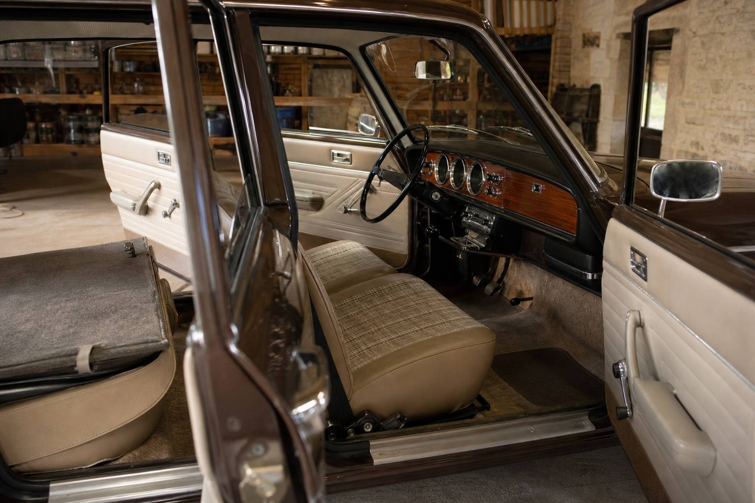 Intérieur restauré d'une Peugeot 204 avec tableau de bord bois verni et banquette à carreaux