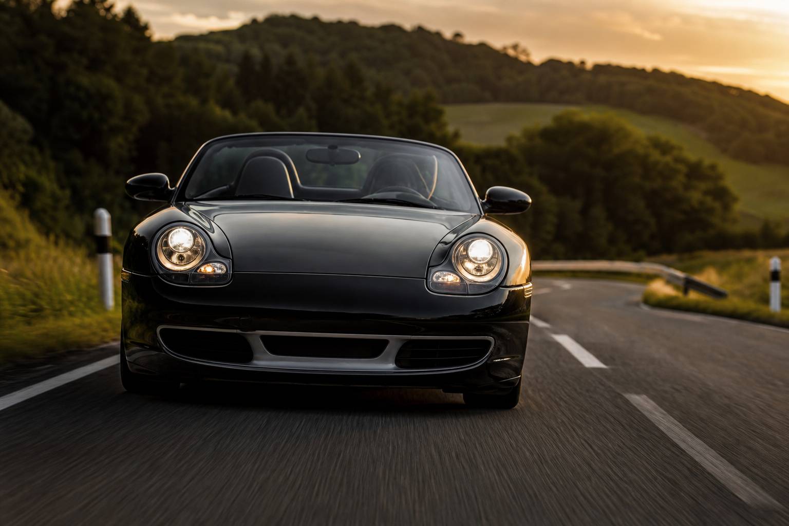 Porsche Boxster 3.2S de face sur route sinueuse, roadster allemand en action